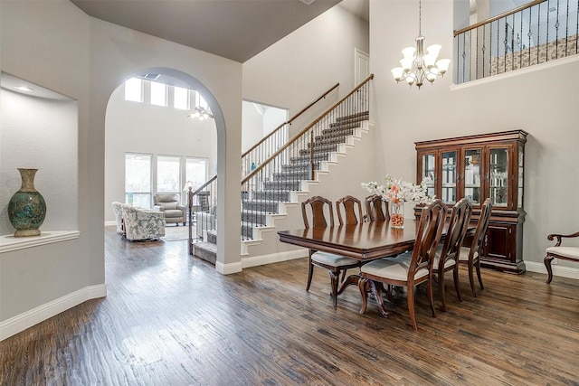 dining room featuring stairway, baseboards, an inviting chandelier, and dark wood finished floors