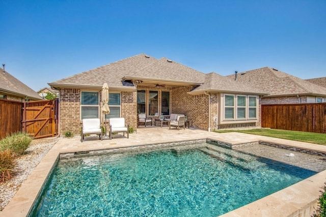 rear view of property featuring a patio, fence, roof with shingles, ceiling fan, and brick siding