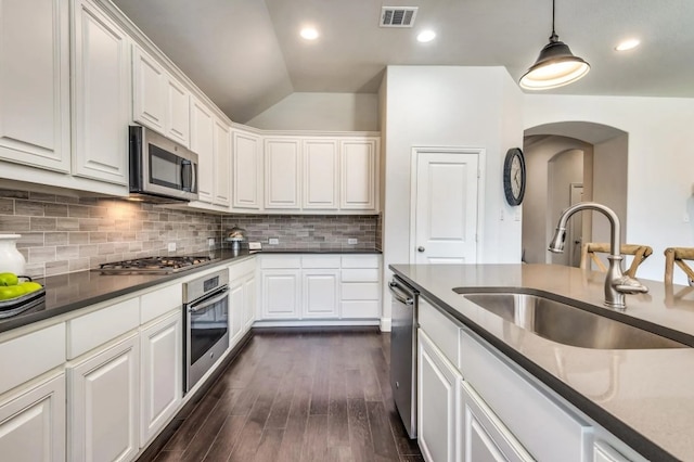 kitchen featuring visible vents, dark wood-style floors, white cabinets, stainless steel appliances, and a sink