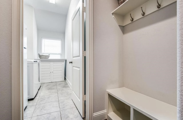 mudroom with light tile patterned floors and washer and dryer