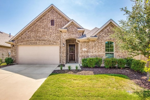 view of front of home featuring brick siding, an attached garage, driveway, and a front yard