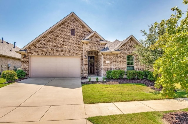 view of front facade featuring brick siding, a shingled roof, a front lawn, concrete driveway, and a garage