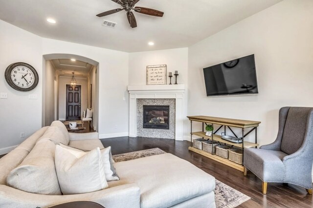 living area with visible vents, dark wood finished floors, arched walkways, baseboards, and ceiling fan