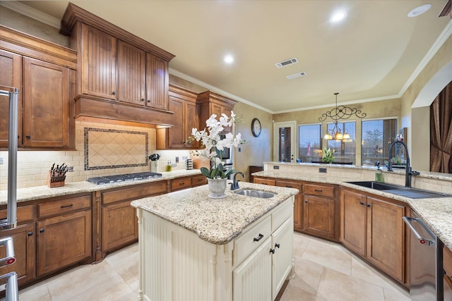 kitchen with a center island with sink, appliances with stainless steel finishes, ornamental molding, and a sink