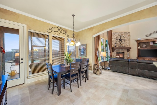 dining area with a chandelier, a fireplace, and ornamental molding