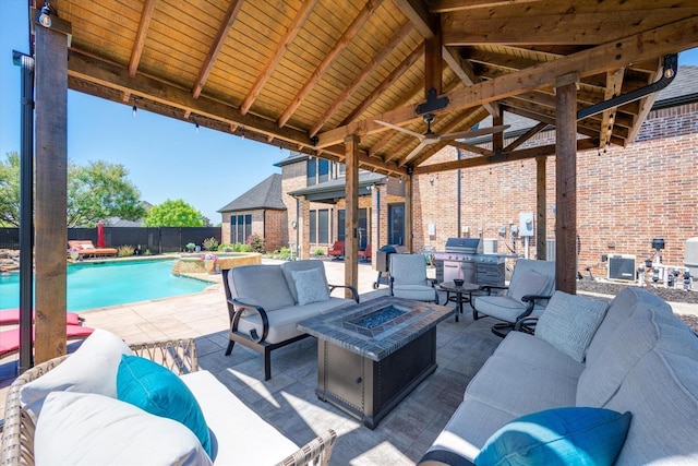 view of patio / terrace featuring a pool with connected hot tub, an outdoor living space with a fire pit, ceiling fan, fence, and a gazebo