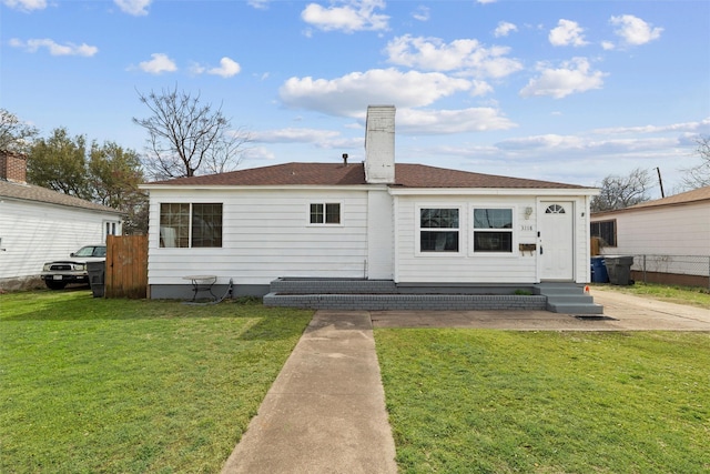 rear view of property with a lawn and entry steps