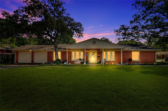 ranch-style home featuring brick siding, driveway, an attached garage, and a front yard