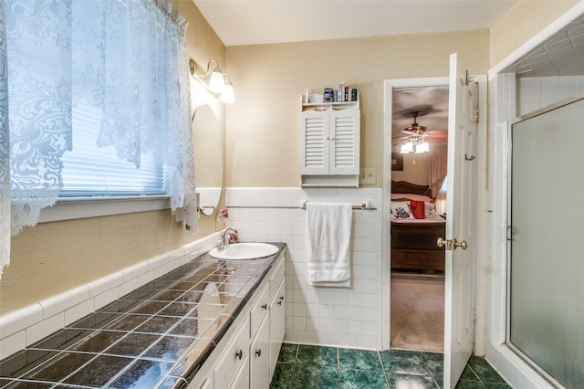 ensuite bathroom with vanity, ensuite bath, tile walls, and a shower stall