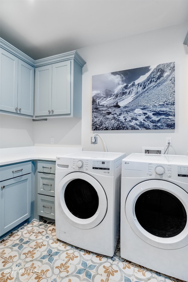 clothes washing area featuring cabinet space, light tile patterned flooring, and washing machine and clothes dryer