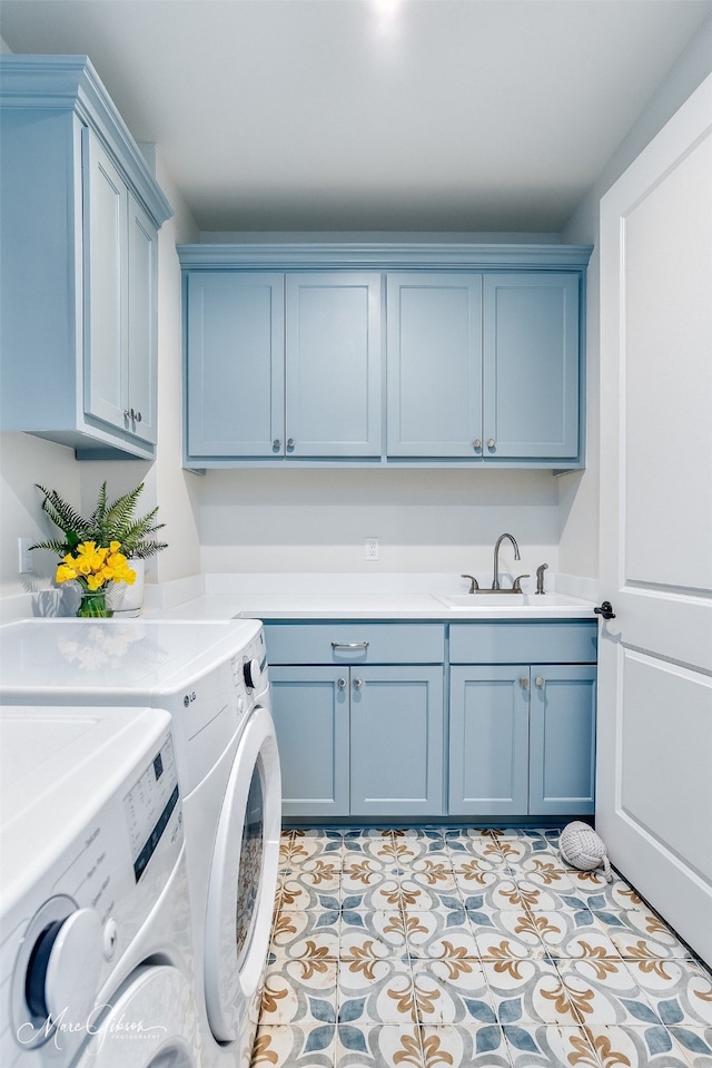 washroom with a sink, cabinet space, light tile patterned floors, and washer and dryer