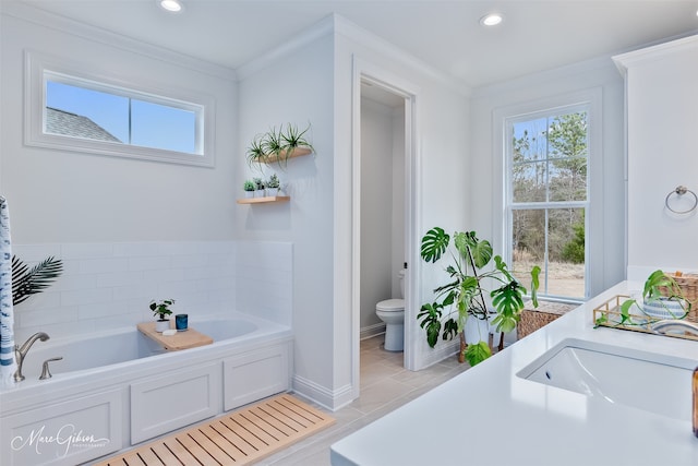 full bathroom featuring toilet, a garden tub, ornamental molding, tile patterned floors, and a sink