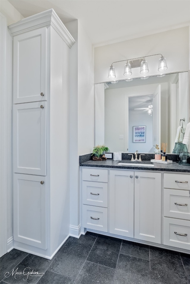 bathroom with ceiling fan, vanity, and baseboards