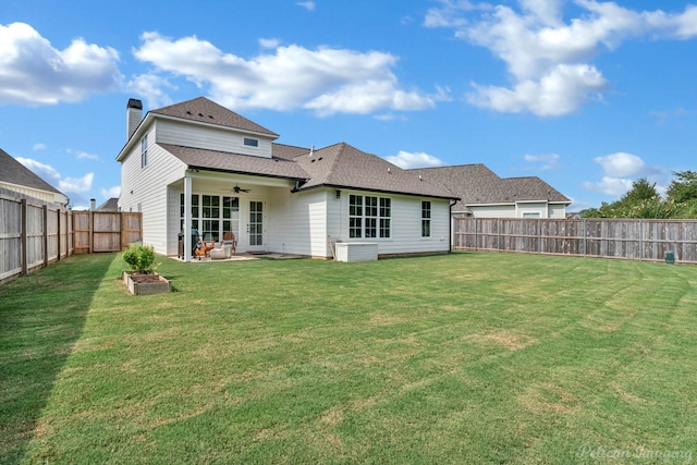 back of house featuring a fenced backyard, a yard, and ceiling fan