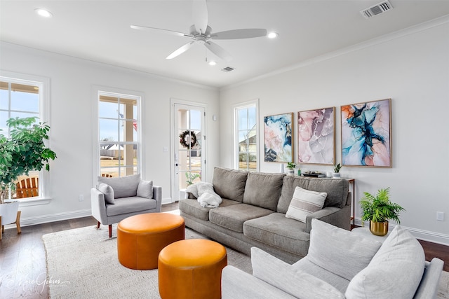 living area featuring visible vents, baseboards, ornamental molding, recessed lighting, and wood finished floors