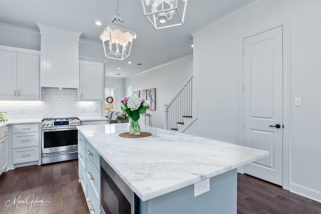 kitchen with stainless steel appliances, an inviting chandelier, ornamental molding, and a center island