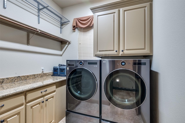 clothes washing area featuring tile patterned floors, cabinet space, and independent washer and dryer