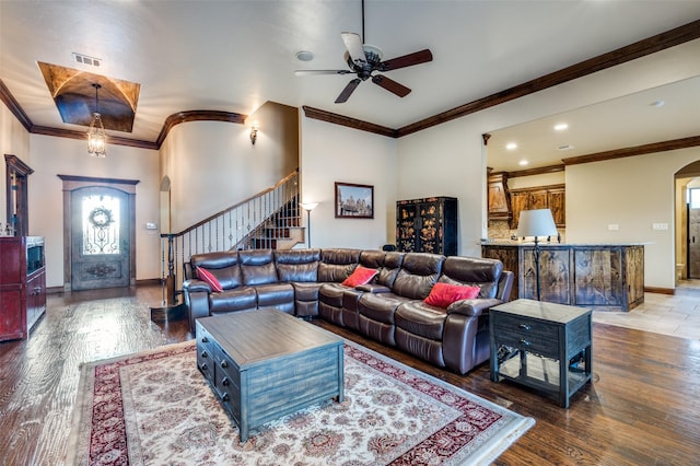 living area with visible vents, wood finished floors, stairway, arched walkways, and baseboards