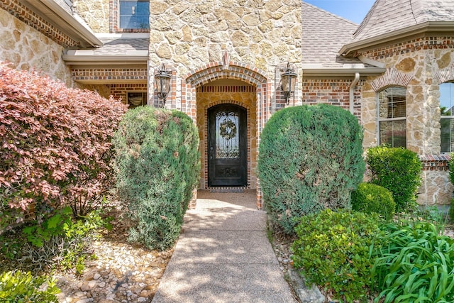 6620 Cedar Grove Dr, North Richland Hills, TX 76182 - view of exterior entry featuring brick siding, stone siding, and a shingled roof