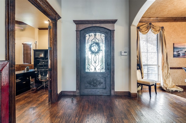 entryway featuring dark wood-type flooring, baseboards, and arched walkways