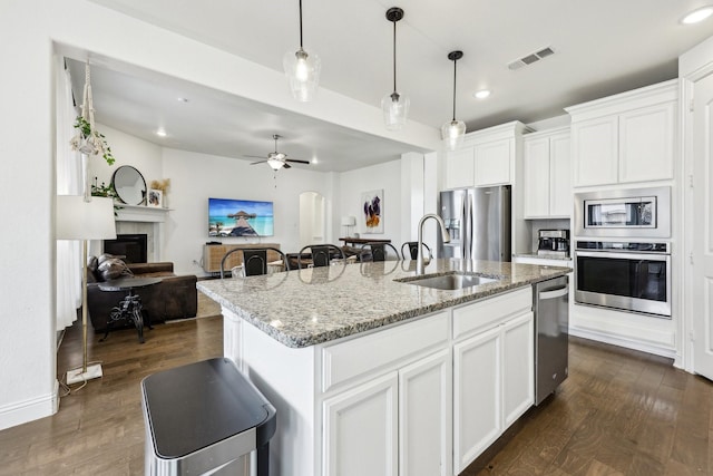 kitchen with visible vents, appliances with stainless steel finishes, dark wood-type flooring, and a sink