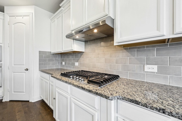 kitchen with light stone counters, stainless steel gas cooktop, dark wood-type flooring, white cabinets, and exhaust hood