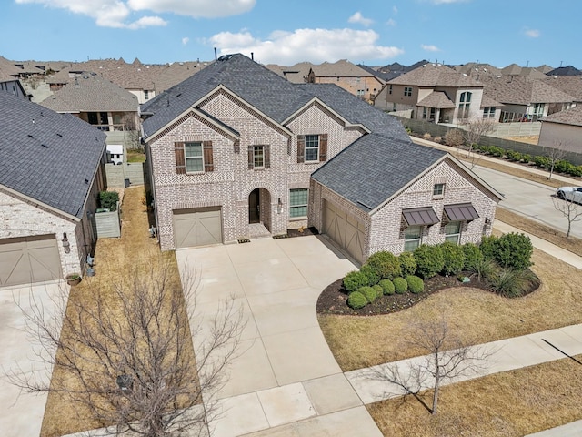 view of front of property with brick siding, a residential view, driveway, and a shingled roof