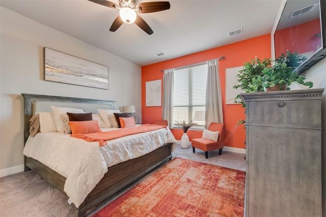 carpeted bedroom with visible vents, baseboards, and ceiling fan