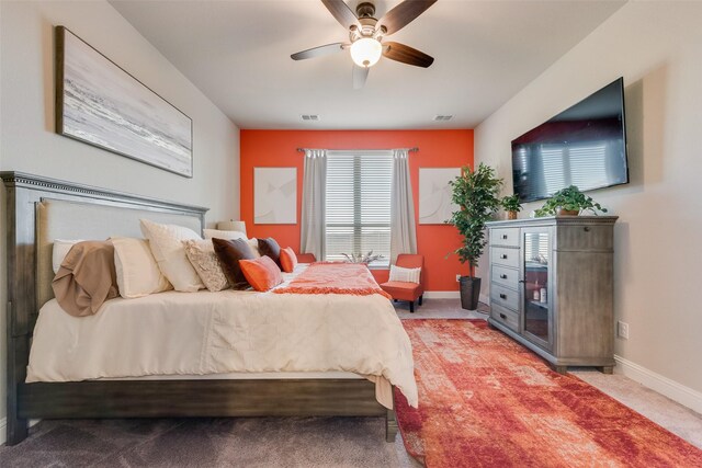 carpeted bedroom with a ceiling fan, baseboards, and visible vents