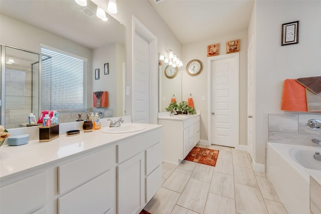 bathroom featuring vanity, a garden tub, and a shower with door