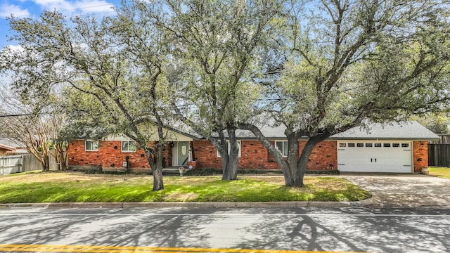 single story home with concrete driveway, a front yard, and fence