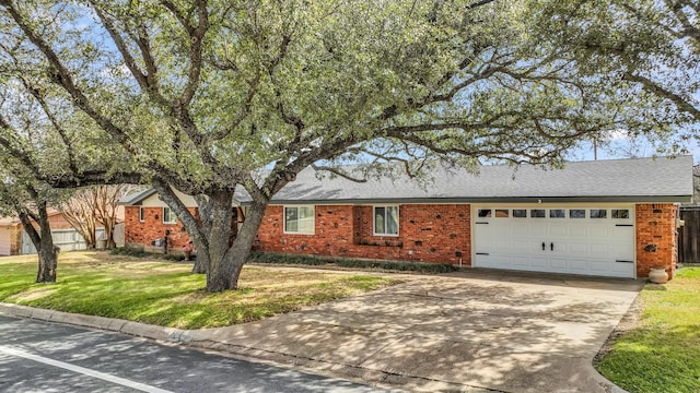 ranch-style home featuring brick siding, a front yard, roof with shingles, a garage, and driveway