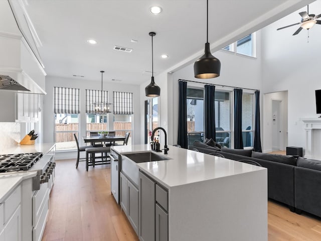 kitchen with visible vents, light countertops, stainless steel gas stovetop, light wood-style floors, and open floor plan