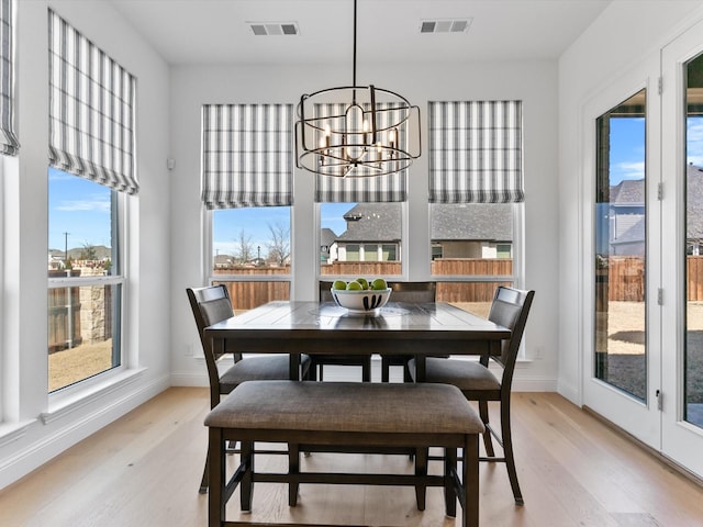 dining room with visible vents, an inviting chandelier, baseboards, and light wood-style floors