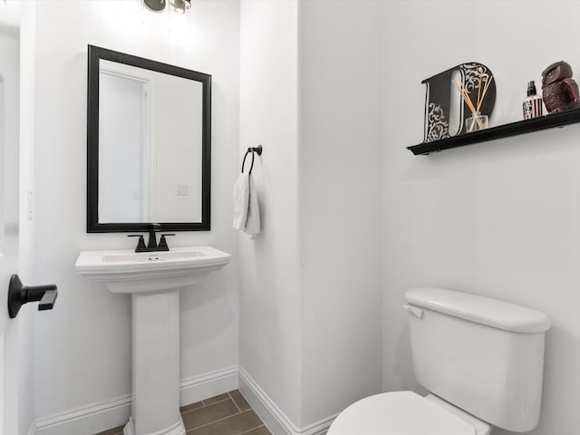 bathroom featuring toilet and baseboards