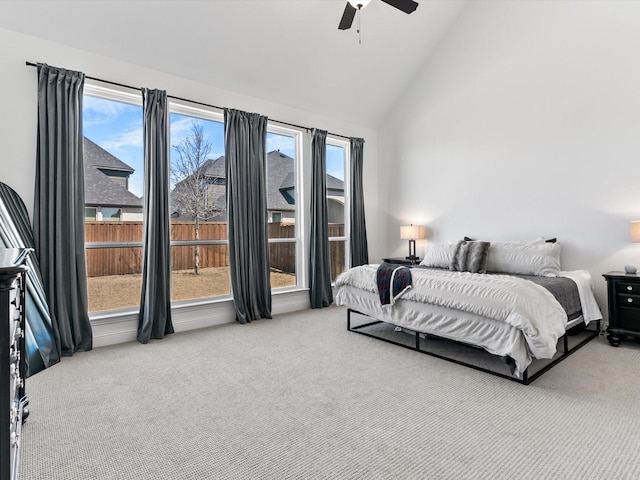 carpeted bedroom featuring high vaulted ceiling and ceiling fan