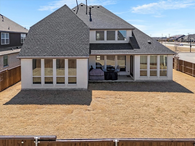 back of house featuring a patio area, brick siding, a fenced backyard, and a shingled roof