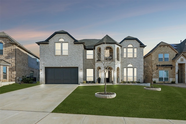 french country style house featuring a yard, a garage, and driveway