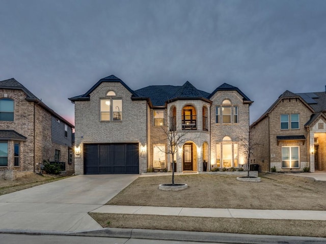 french country home with concrete driveway and a garage