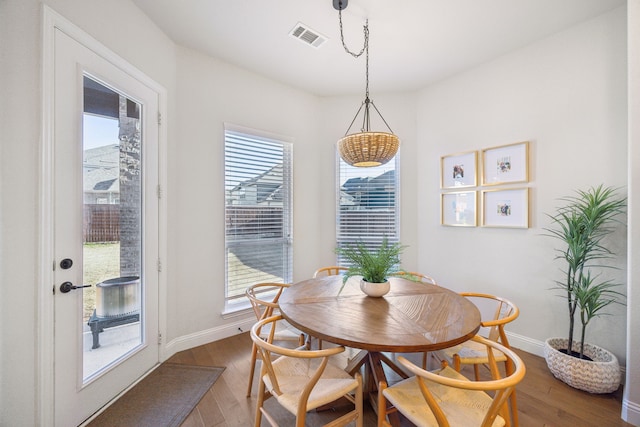 dining room with wood finished floors, visible vents, and baseboards