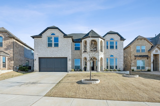 french country home featuring a garage and driveway