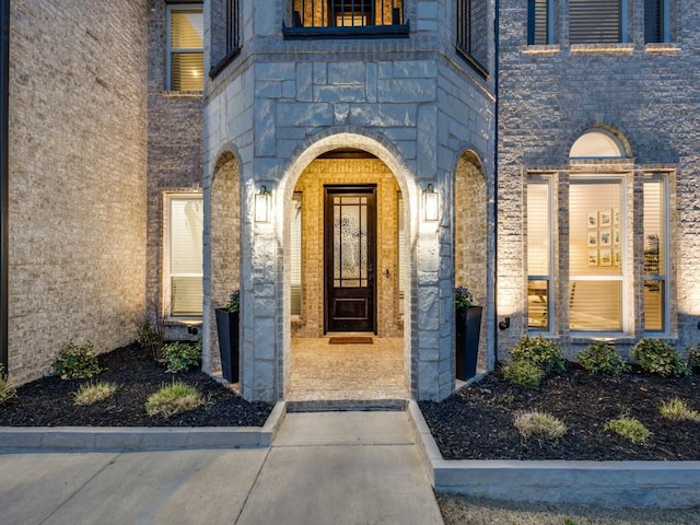 doorway to property featuring stone siding and brick siding