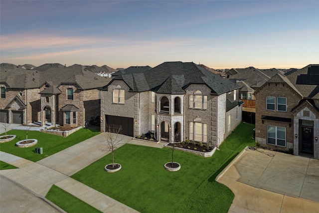 french country style house with a residential view, a garage, concrete driveway, and a yard