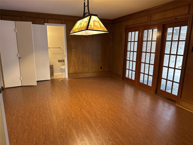 empty room featuring wood finished floors and wood walls