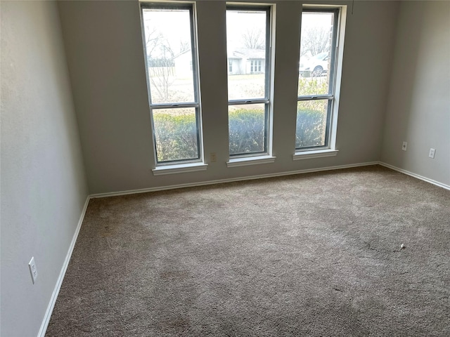 carpeted empty room with baseboards