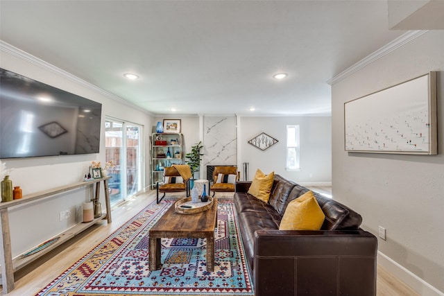 living area with baseboards, a premium fireplace, light wood-style flooring, recessed lighting, and ornamental molding