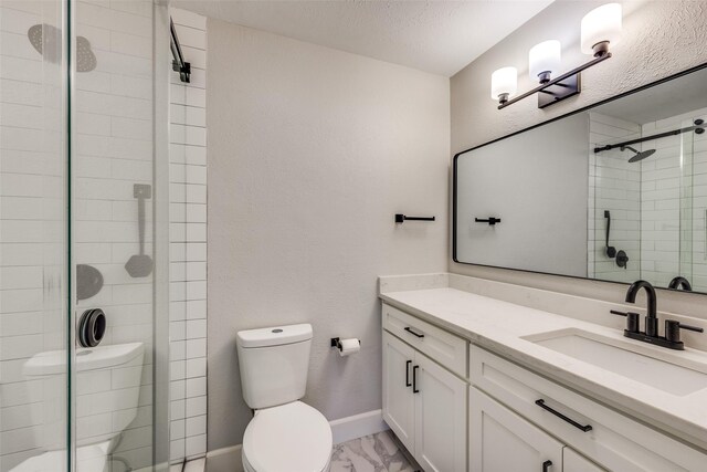 bathroom with baseboards, toilet, a stall shower, marble finish floor, and vanity