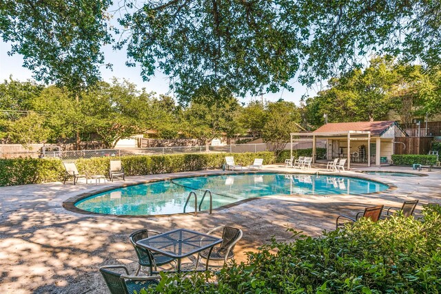 pool featuring fence and a patio area