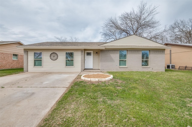 single story home featuring cooling unit, brick siding, and a front yard