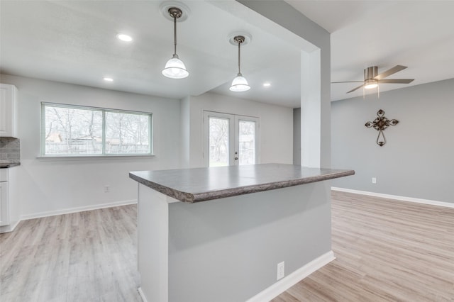 kitchen featuring dark countertops, white cabinets, french doors, and light wood-type flooring